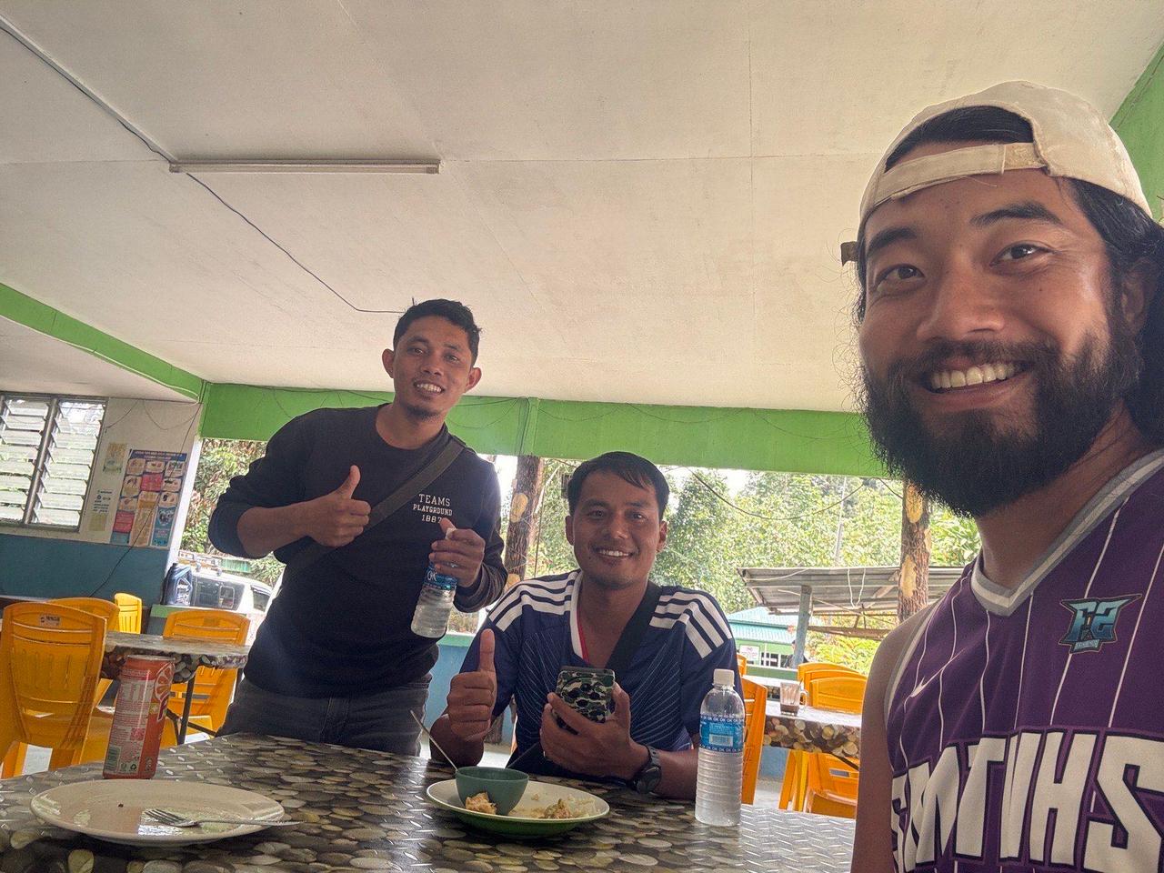 Sharing a meal with locals at a rest stop, one of them wearing a Japan jersey