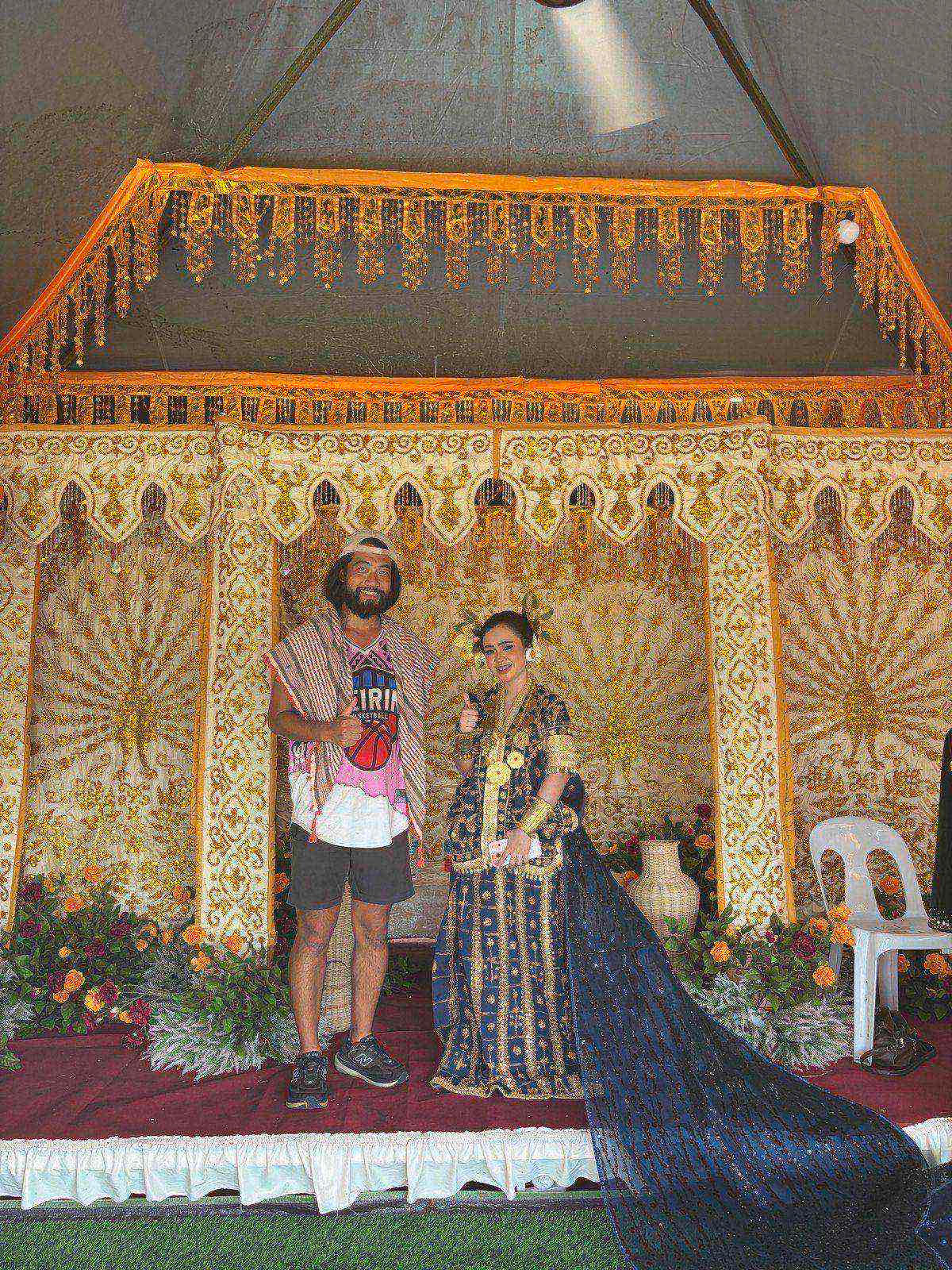 Posing with a woman in an ornate gold Mandar wedding costume