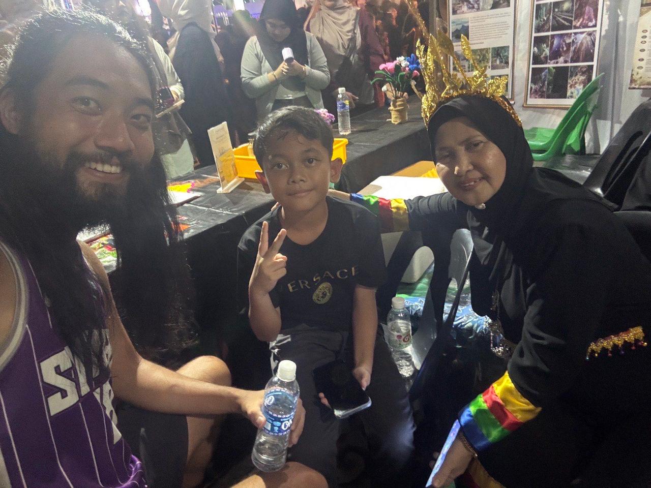 Sharing water bottles with a family I met at the festival at night