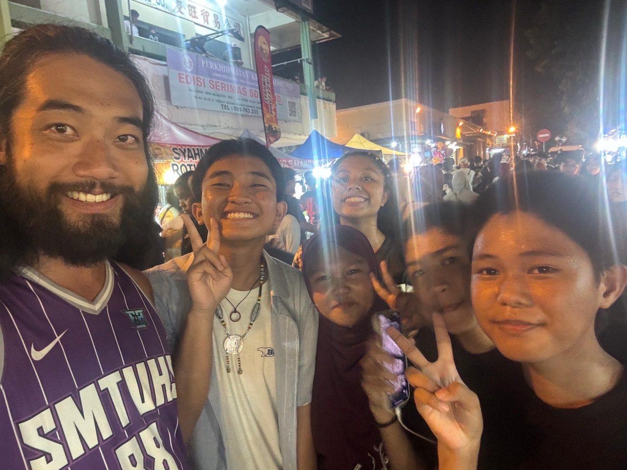 A group photo with local kids at the crowded night market