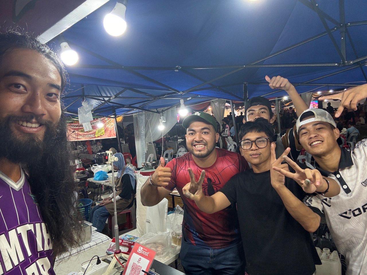 A group photo with friends at a food stall late at night