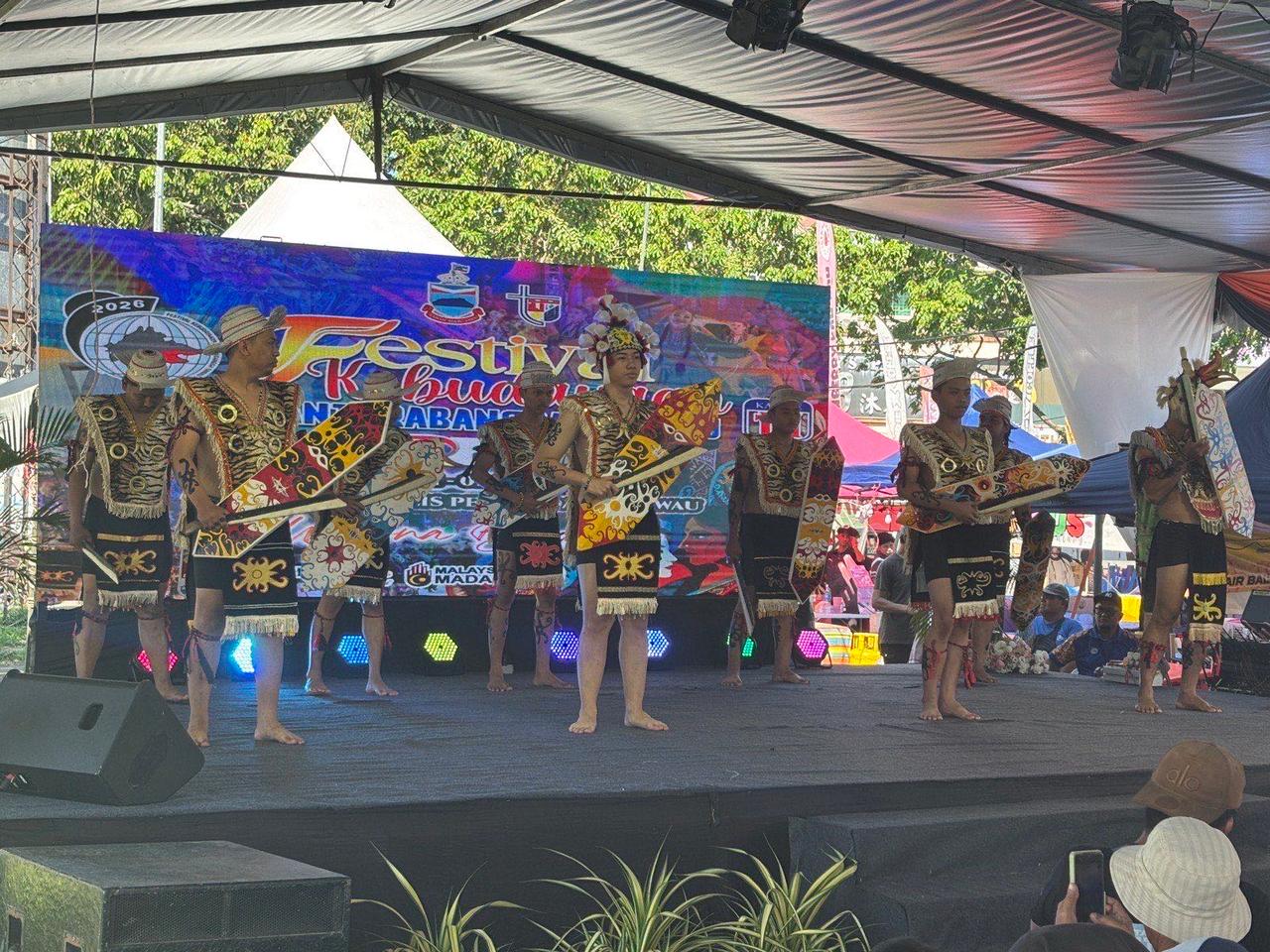 A group of dancers in traditional warrior costumes performing on the festival stage