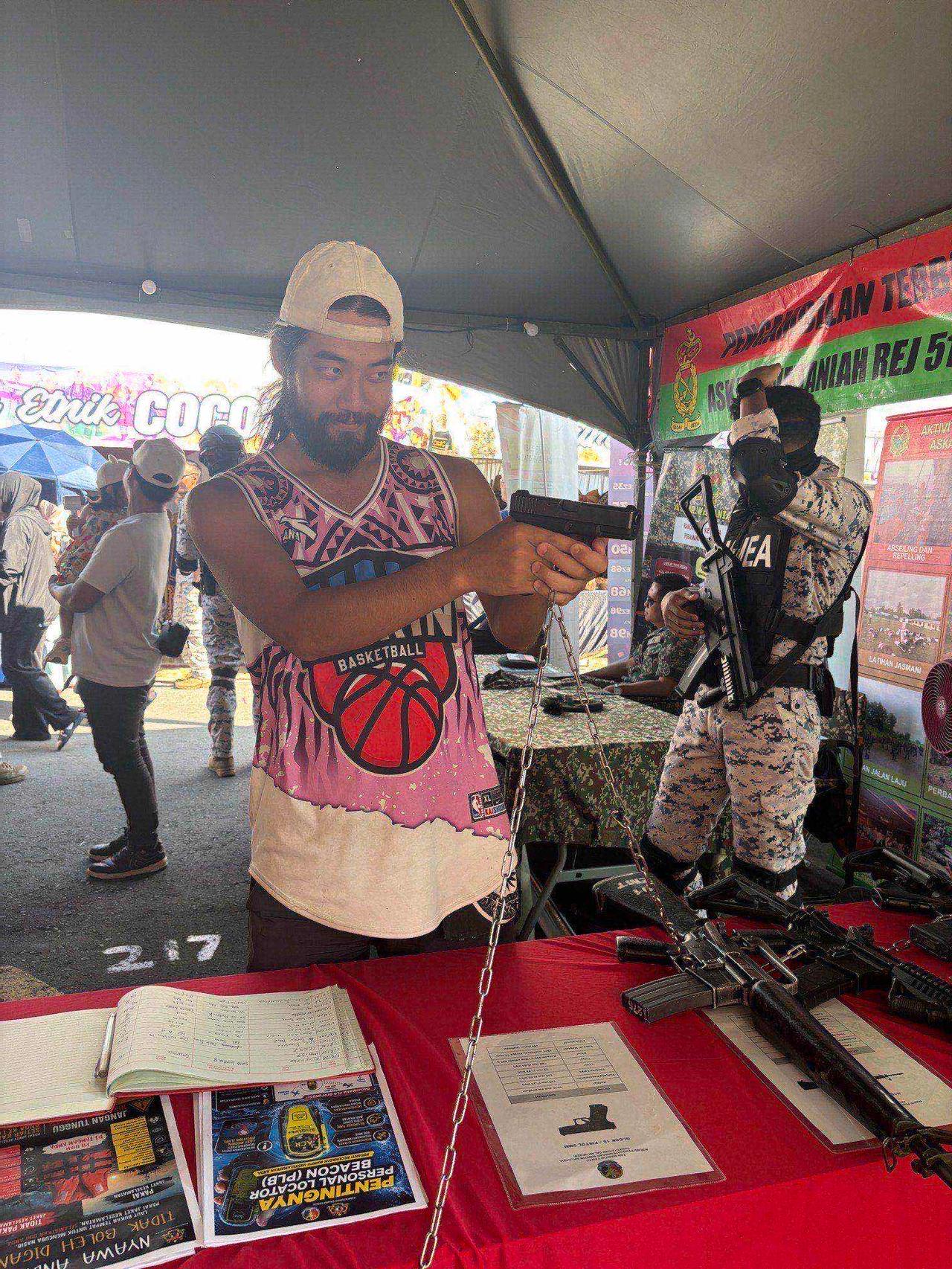 Holding a real pistol at the police and armed forces exhibition booth