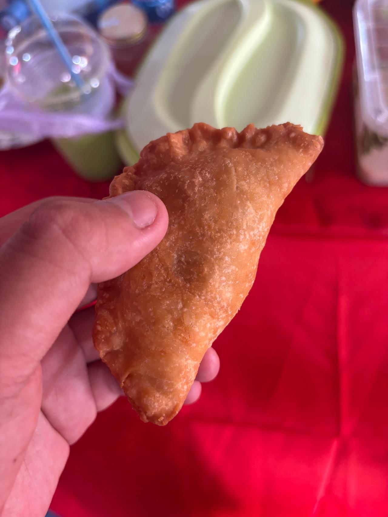 Holding a freshly fried curry puff pastry