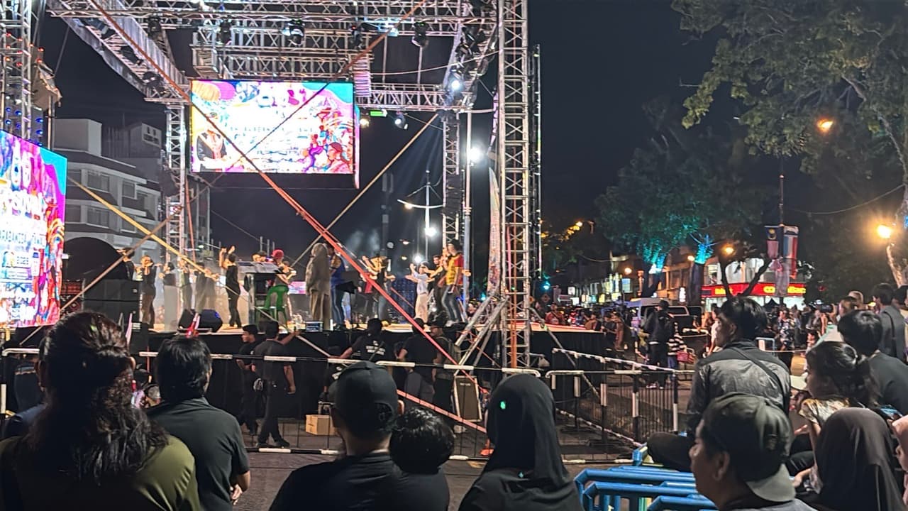 The main festival stage lit up at night with performers and a large crowd