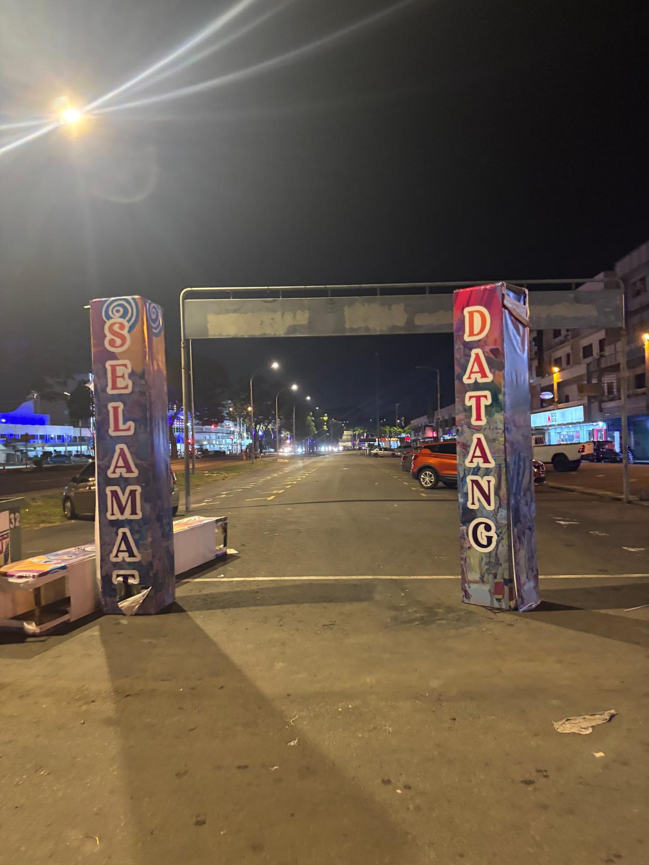 A quiet Tawau street lit up at night