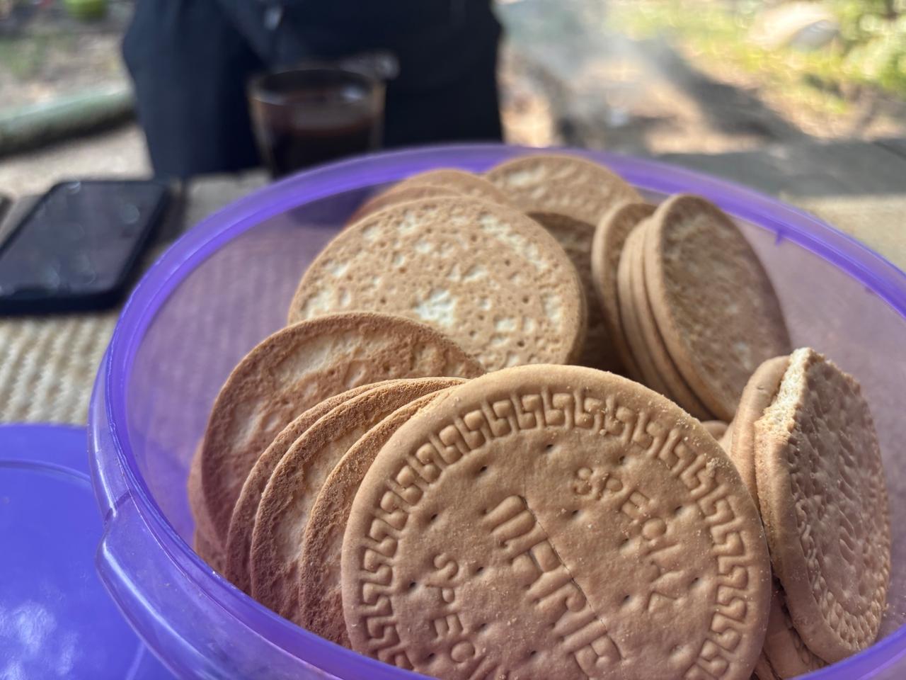 A plastic tub filled with round Indonesian biscuits called Kue