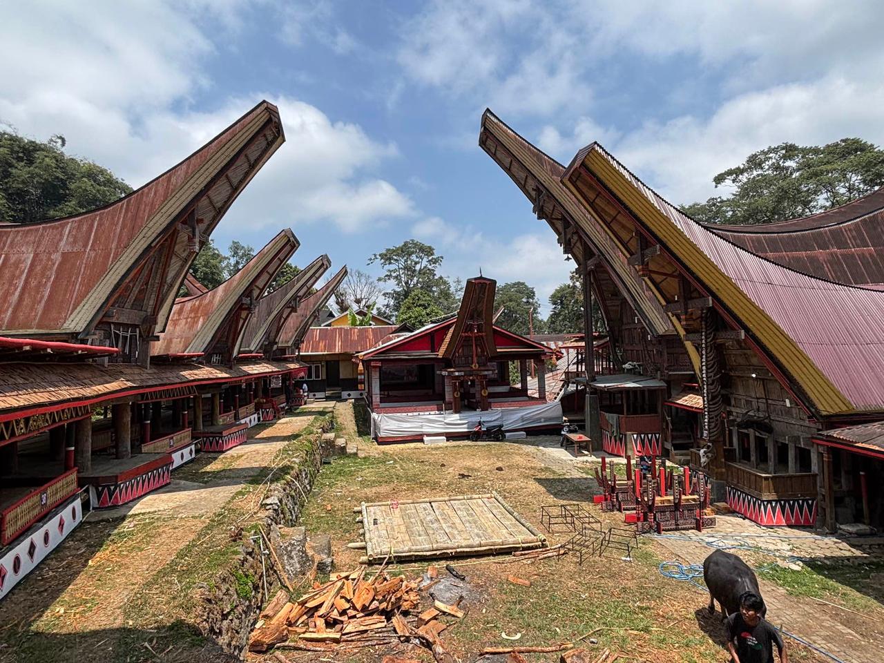 A row of traditional Tongkonan houses with steeply curved roofs in a Toraja village