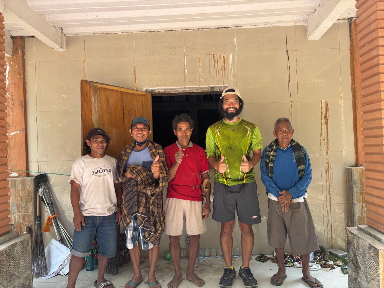 The author posing with local Torajan family members at the entrance of the mausoleum
