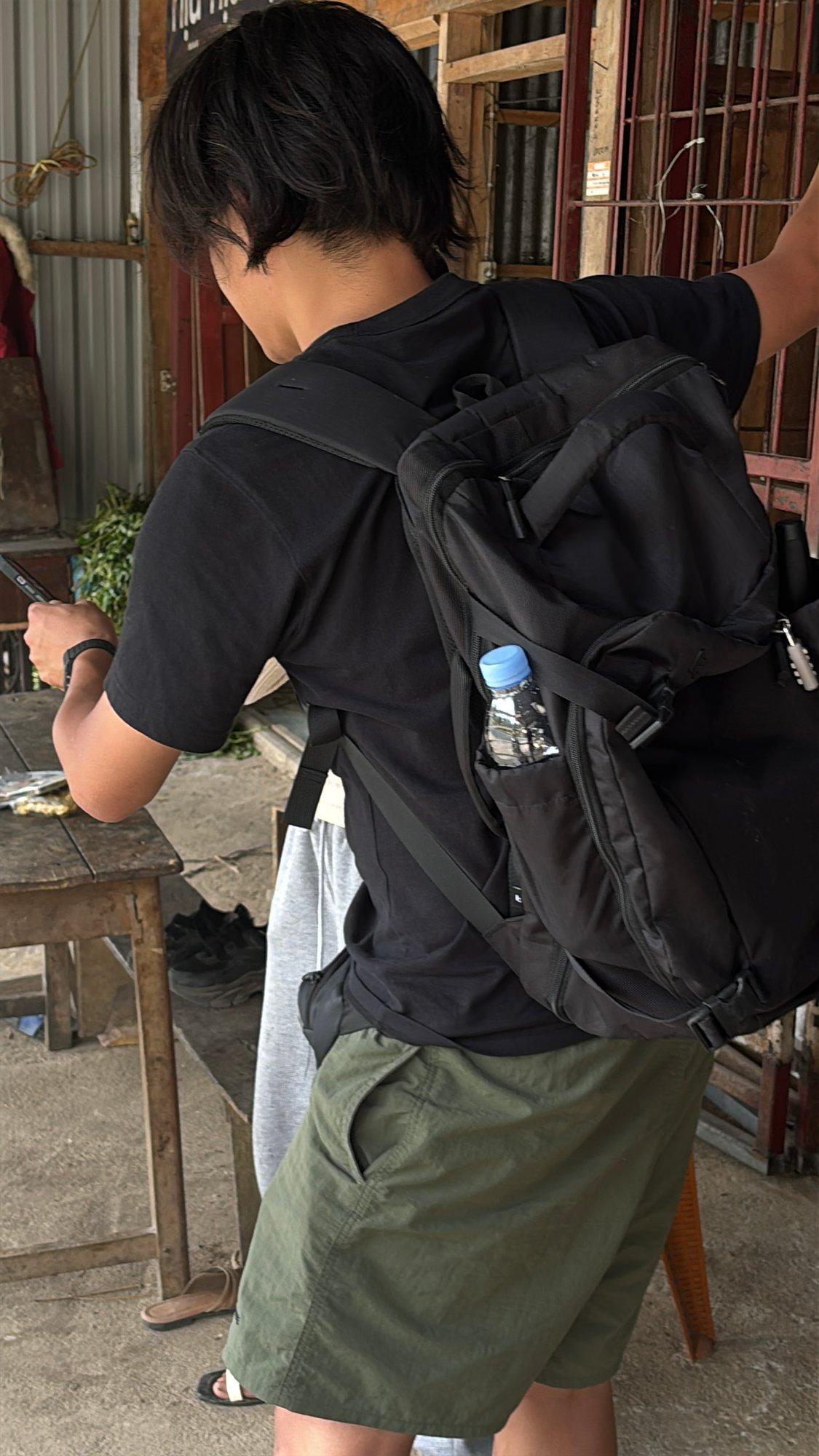 A traveler with a backpack walking through a rural farm building