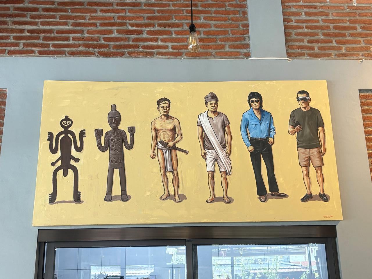 A mural on a cafe wall depicting stylized Torajan ancestor figures evolving into modern people