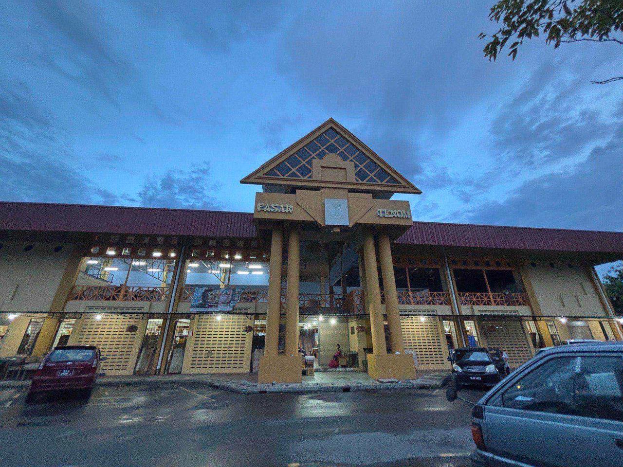 The Pasar Tenom market building lit up at dusk