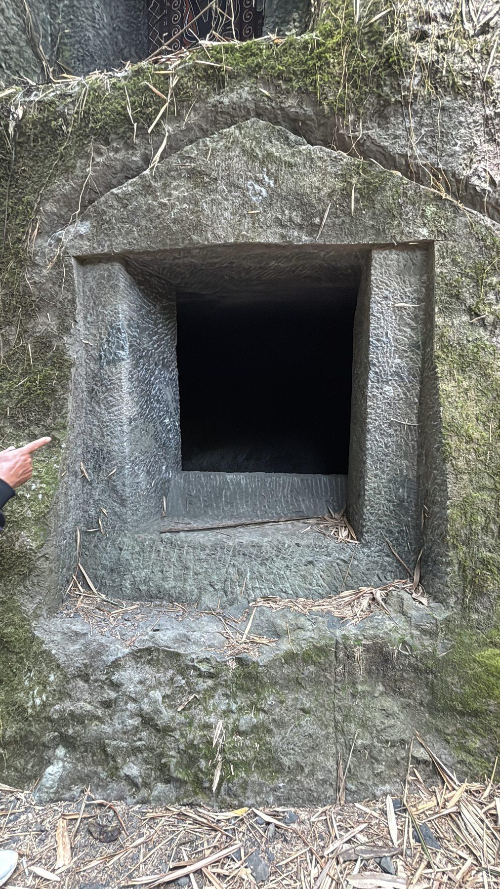 The empty, doorless opening of a newly carved chamber inside the boulder, cut into a clean rectangle, its interior dark.
