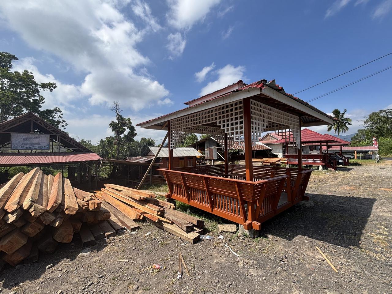 Tumpukan kayu besi di samping sebuah paviliun tradisional yang masih setengah jadi dalam proses pembangunan di Woloan.