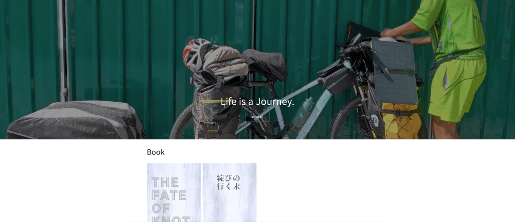 A cyclist wearing a bright green outfit adjusts gear on a fully loaded bicycle next to green shipping containers. The text